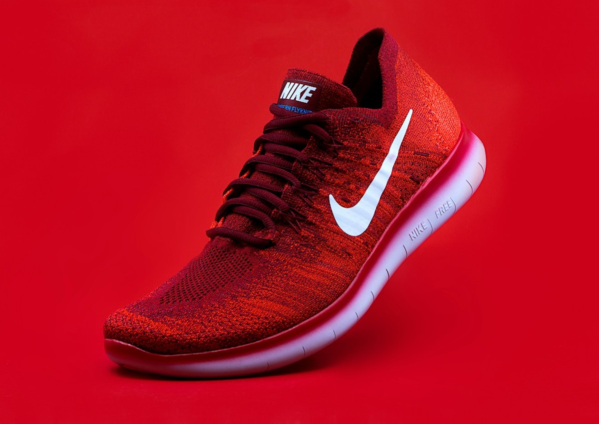 Red athletic sneaker against a red backdrop