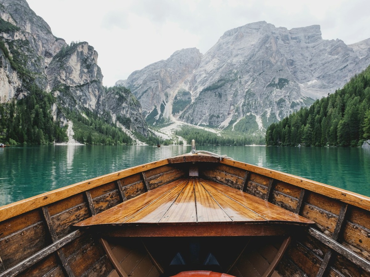 Wooden boat on a calm alpine lake with mountains
