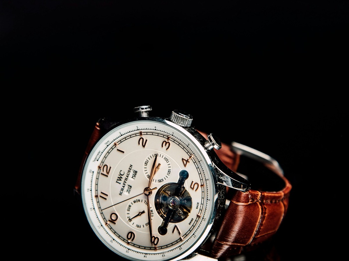 Mechanical watch with brown leather strap against black
